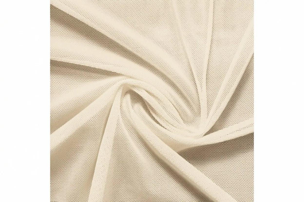 Power mesh knit fabric in pale champagne cotton with fine open structure, manufactured at Apex Corporation knitwear factory in Karachi Pakistan